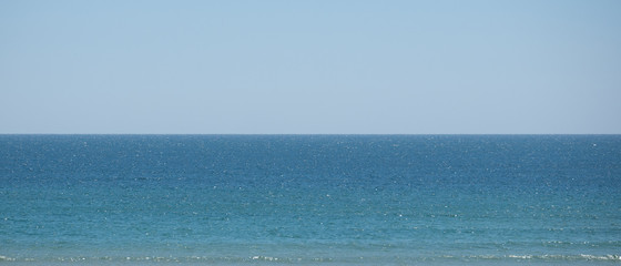 Obraz premium Sea and sky, with horizon exactly in middle, dividing image in half horizontally. Web banner or background.