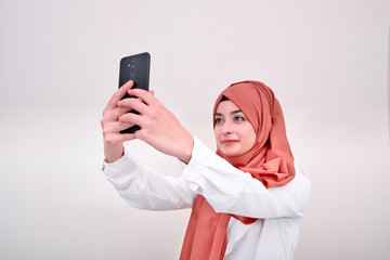 Hijab muslim woman taking selfie, portrait of muslim girl take photo, background is isoalted