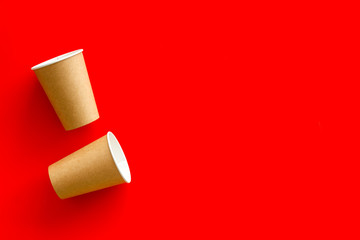 Paper cups for coffee to go on red background top view mockup