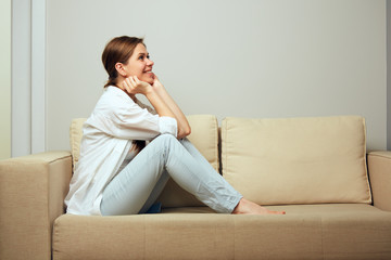 woman relaxing at home sitting on sofa.