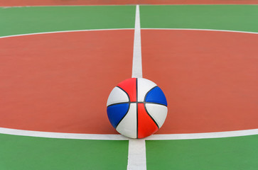 colorful basketball ball on the central circle of an outdoor court