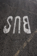 The word BUS painted on the asphalted gray floor