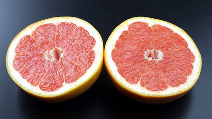 cut grapefruit on a dark background. Healthy and vitamin food.
