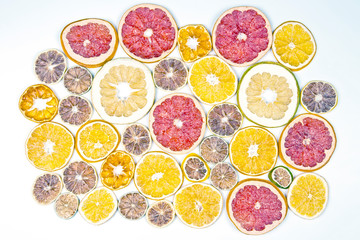 Dried slices of various citrus fruits on white background.