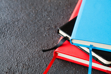 Stack of colorful notebooks for writing or books on dark background