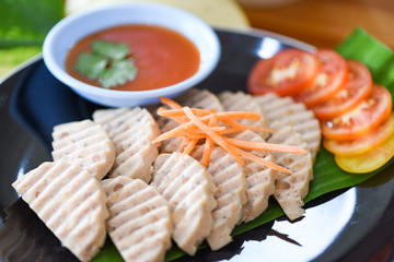 White pork sausage asia - Mooyor in thai - fermented pork sausage slice on plate with tomato sauce