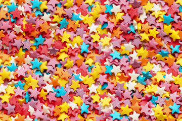 Fototapeta na wymiar Sugar stars for baking decoration. Confectionery multi-colored topping closeup. Seamless background. You can create an endless picture