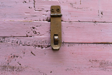 Background in the form of an iron canopy for a lock on an old pink wooden chest