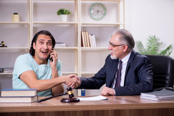 Young man visiting experienced male lawyer