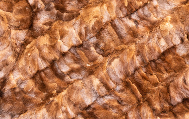 Background in the form of stitched pieces of natural fur light brown color with diagonal stripes