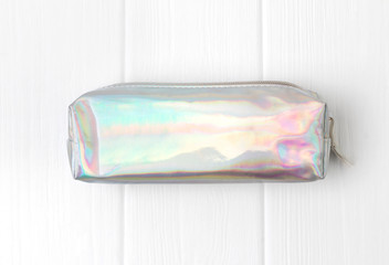 Holographic pencil case on white wooden background