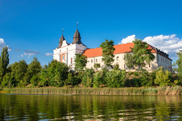 Church, former benedictine abbey in the village Mogilno / Poland. view from the lake - water...
