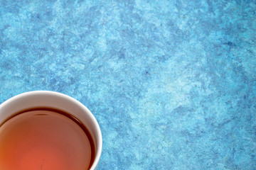 Obraz na płótnie Canvas cup of tea on a blue bark paper