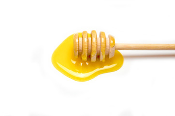 spoon for honey and liquid honey, selective focus white background
