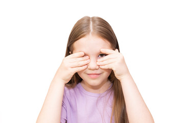 The little girl spies because of palms. It is isolated on a white background.