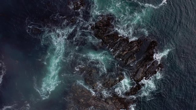 Top down aerial view of giant ocean waves crashing and foaming