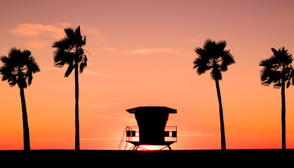 Beach Sunset with lifeguard tower, coastline and palm trees, USA.