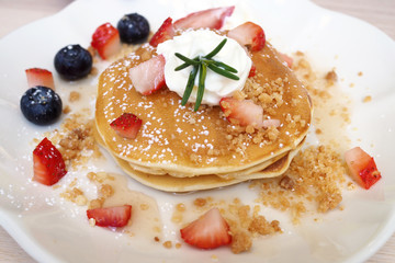 Pancakes sprinkled with strawberries and blueberries
