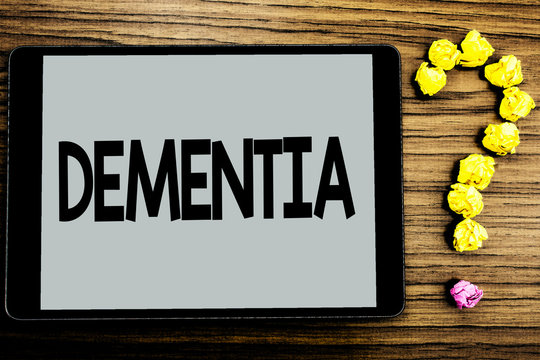 Conceptual hand writing showing Dementia. Business photo showcasing Long term memory loss sign and symptoms made me retire sooner written Tablet Screen wooden background Paper Ball Ask for
