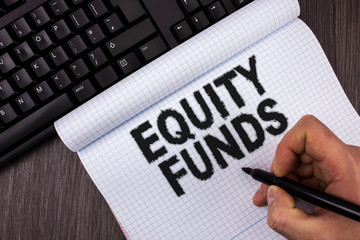 Conceptual hand writing showing Equity Funds. Business photo text Investors enjoys great benefits with long term investment written by Marker in Hand Notebook wooden background Keyboard