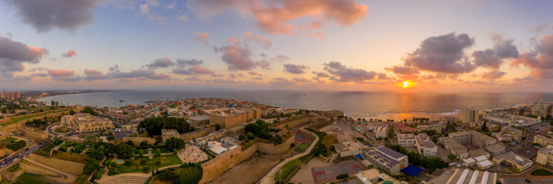 Aerial summer sunset view of Acco, Acre, Akko medieval old city with green roof Al Jazzar mosque and crusader palace, city walls, arab market,  knights hall, crusader tunnels,  in Israel