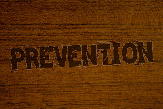 Conceptual hand writing showing Prevention. Business photo showcasing Stopping something from happening Healthcare ProtectionBold brown letters words ideas on wooden background concept messages