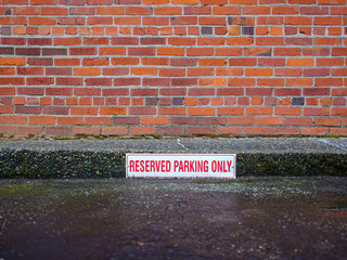 Reserved Parking Only with red brick wall