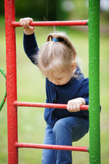Fototapeta premium Cute little girl playing on the playground