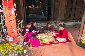 Vietnamese family having Tat Nien meal, the penultimate New Years Eve, the meal finishing the...