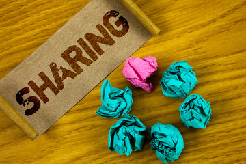 Handwriting text writing Sharing. Concept meaning To Share Give a portion of something to another Possess in common written Folded Cardboard Paper piece wooden background Paper Balls.