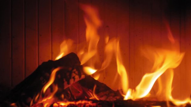 Burning Flame At Fireplace on wooden logs. Medium shot of a yule log burning in a fireplace.
