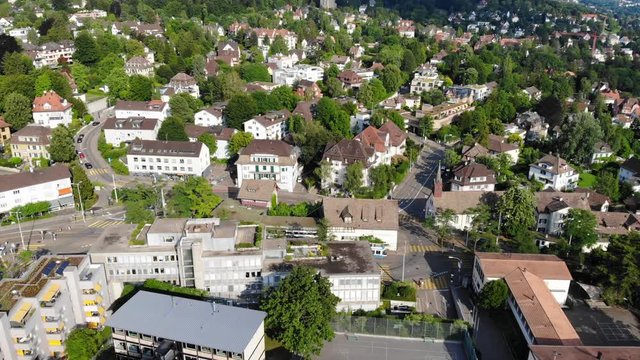 Beautiful drone aerial of Z&uuml;rich, the biggest city in Switzerland. You see a tram (public transport ZVV) moving in between the houses.