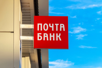 Sign in Russian "Post Bank" on the facade of the building.  Front view. 