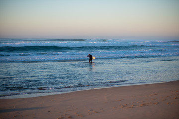 Surfing heading into the ocean