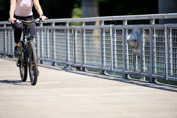 Woman rides a bicycle along a path along a river