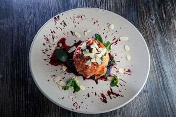 tasty baked apple dessert with syrop, nuts and mint