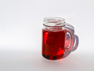 summer berry lemonade in glass jar-mug with lid and  straw on  white background.
