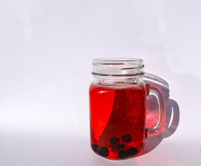 summer berry lemonade in glass jar-mug with lid and  straw on  white background.