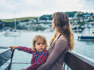 Fototapeta na wymiar Young mother and toddler on boat in harbor