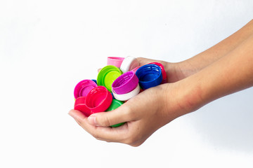 plastic bottles cap in hand for recycling To help save the world