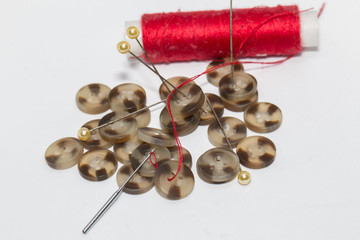 Needle with thread and button isolated on white , needlework and tailoring concept - sewing buttons, needles and pins. - Powered by Adobe