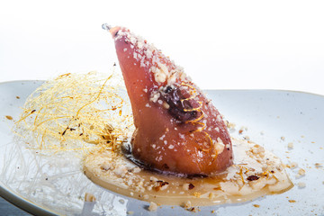 closeup whole pear finely decorated with caramel against white