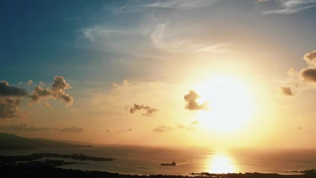 Aerial footage of a cargo ship sailing into Montego Bay Jamaica at sunset.