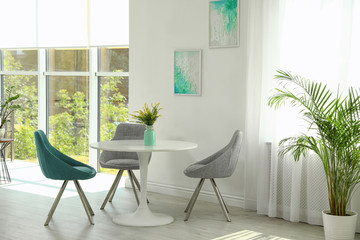 Modern living room interior with round table and stylish chairs