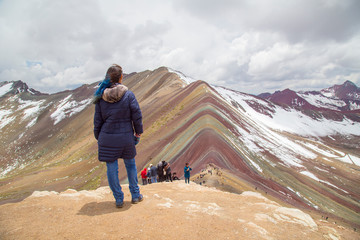Friends with panoramic views. Hiking scene in Vinicunca, Cusco region, Peru. Montana of Seven Colors, Rainbow Mountain.