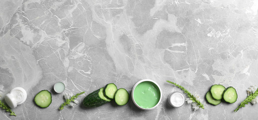 Flat lay composition with jars of body cream on grey marble background. Space for text