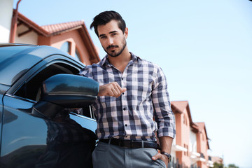 Attractive young man near luxury car outdoors