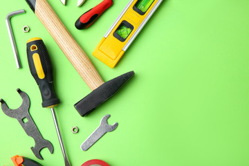 Set of repair tools on light green background, flat lay. Space for text