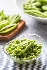 Fresh green pea seeds in bowl on kitchen table