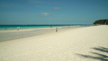 Sandy beach with tourists and turquoise water in the tropical resort of Boracay, Philippines....